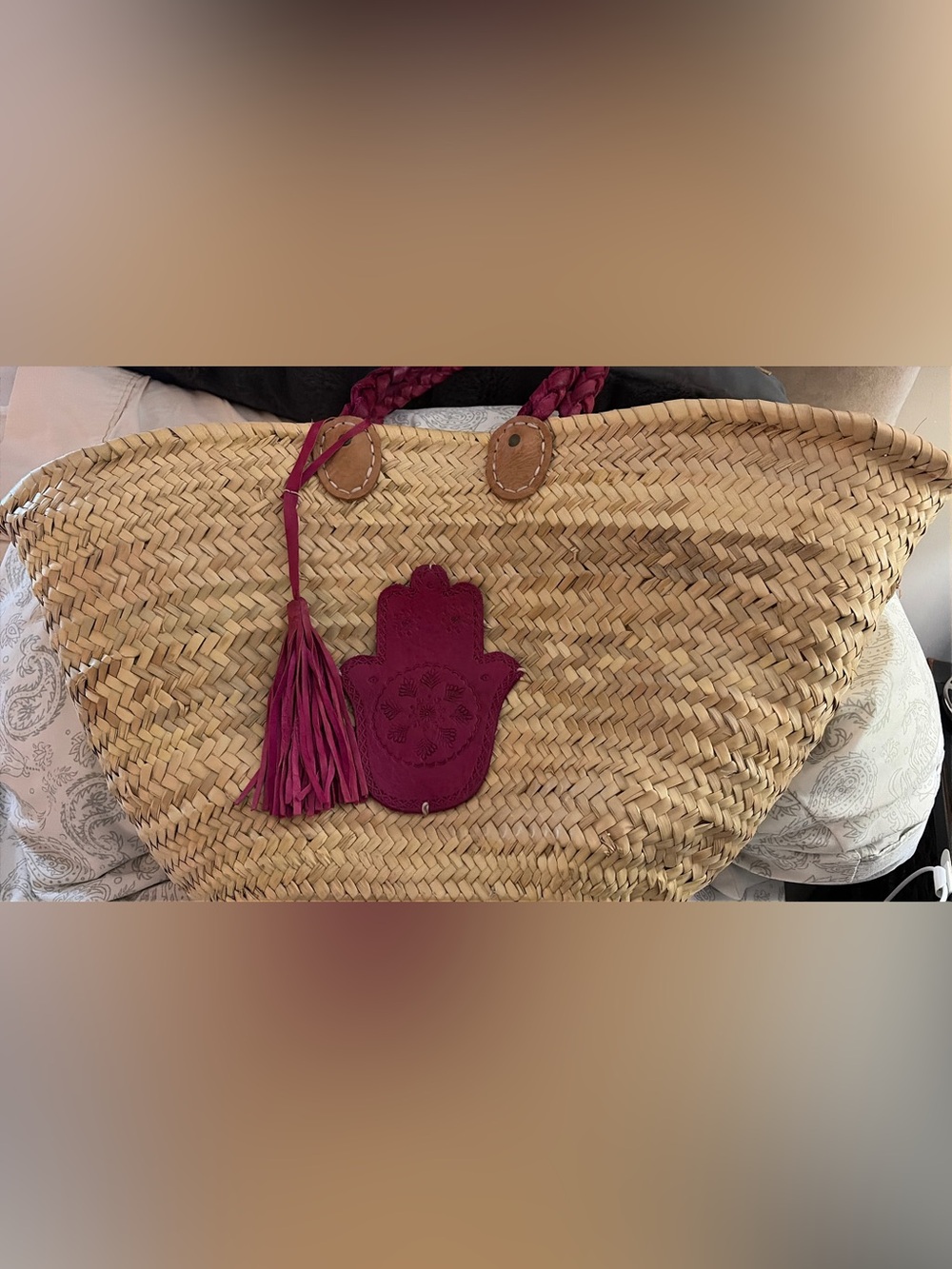 Moroccan straw market tote bag featuring woven palm leaf straw, braided leather